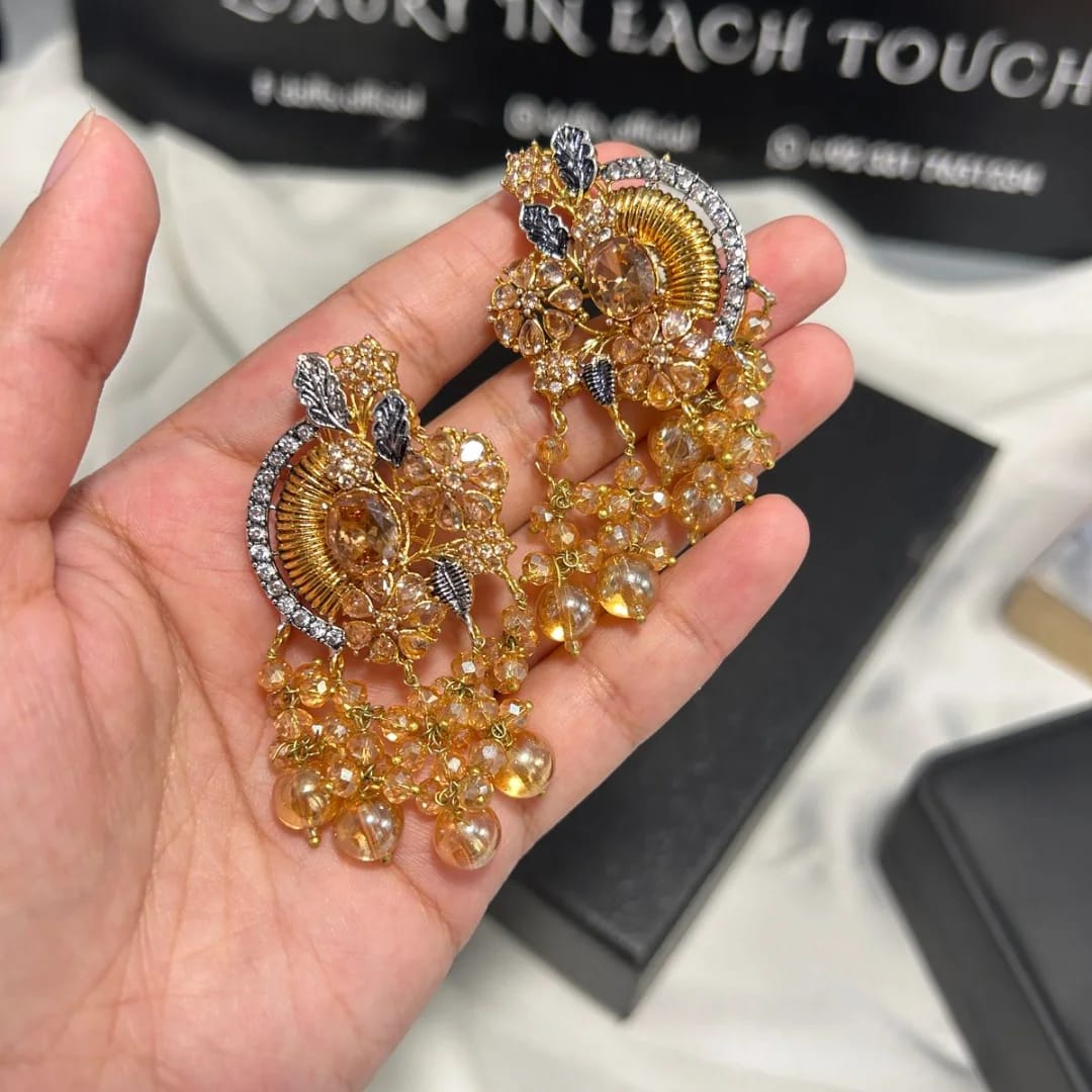 Gold and silver decorative item held in a hand with a blurred background