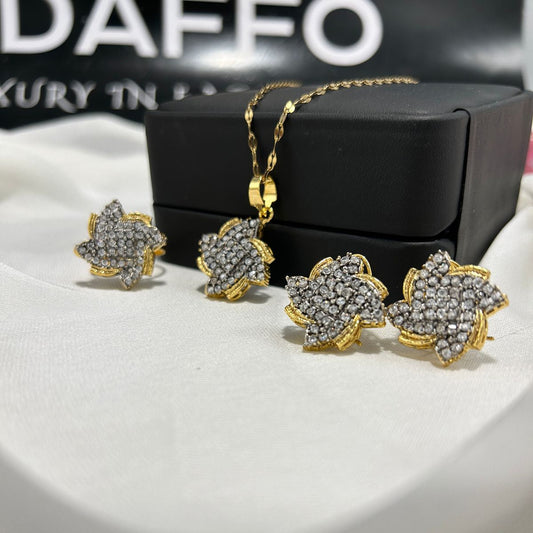 Gold and diamond jewelry set on a white surface with a black box in the background.