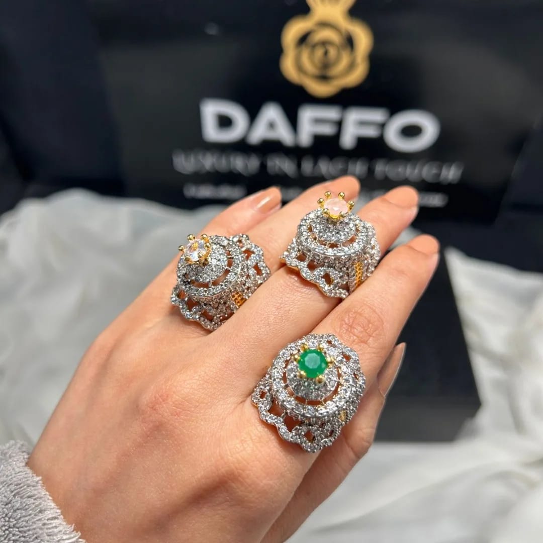 Three ornate rings with gemstones on a hand, with a DAFFO branded box in the background. goldplated adjustable rings 